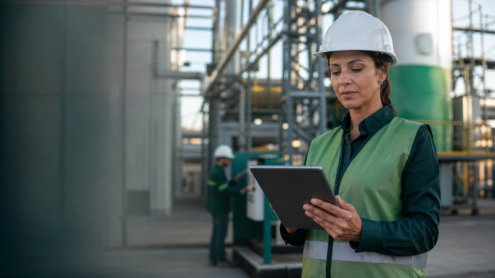 Profissional de segurança do trabalho analisando dados em um tablet em uma indústria